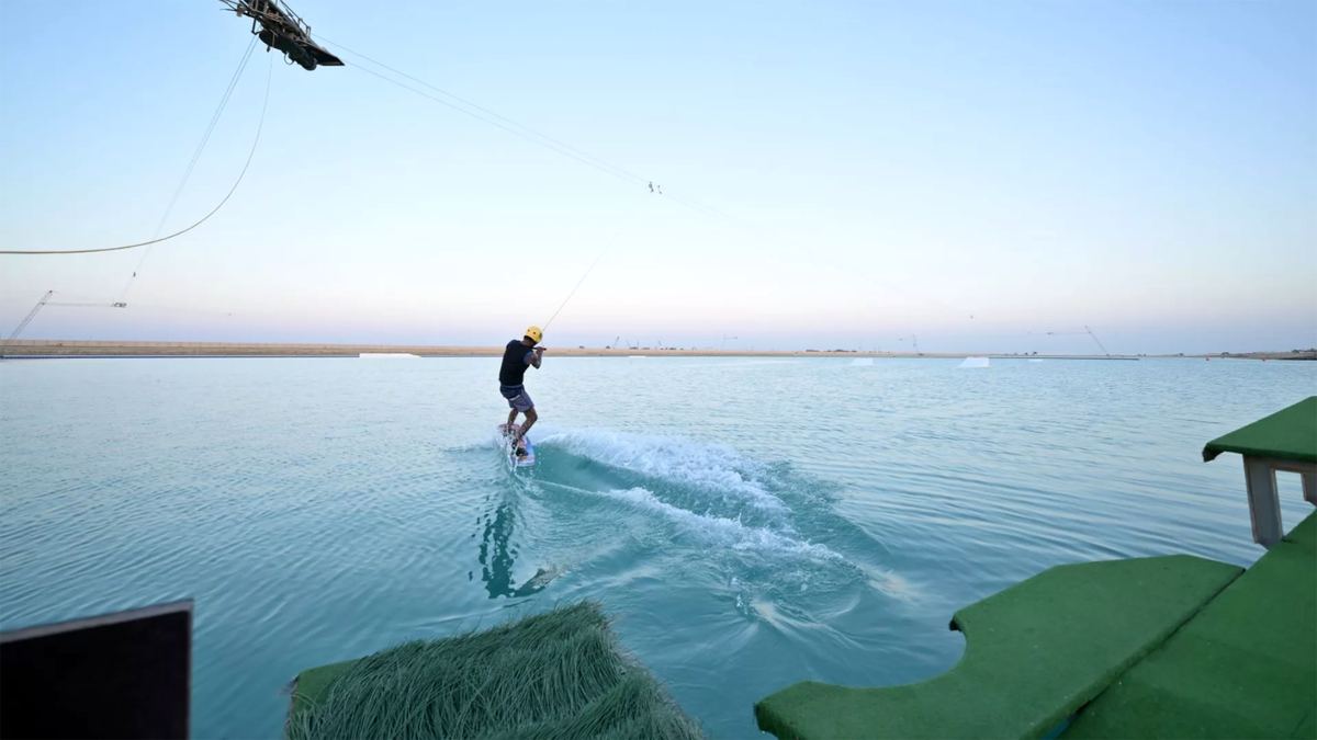 Wakeboarder riding the cable park at dusk, seen from the launch dock at Kona Marine Sport Club